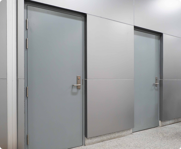 A thick, industrial-grade steel security door with multi-point locking being installed in a commercial facility.