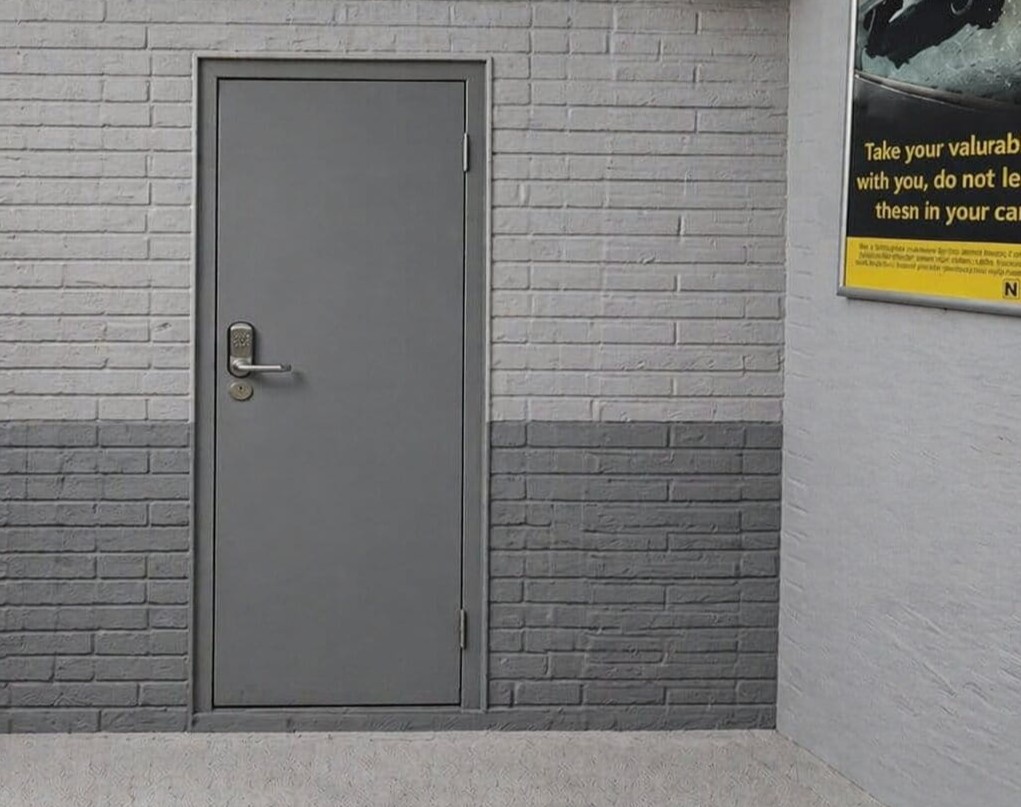 A secure steel louvered door with a proximity card reader installed at a residential cycle storage shed.