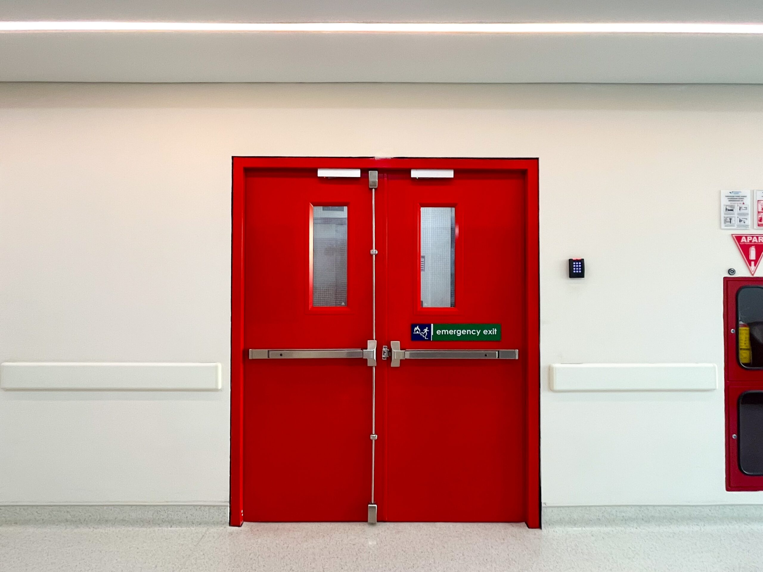 A high-security emergency exit door featuring an internal panic bar for safe egress and a flush external face for security.