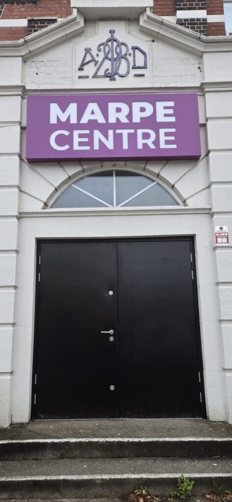 Black steel double doors under an arched fanlight at a church entrance in Coventry
